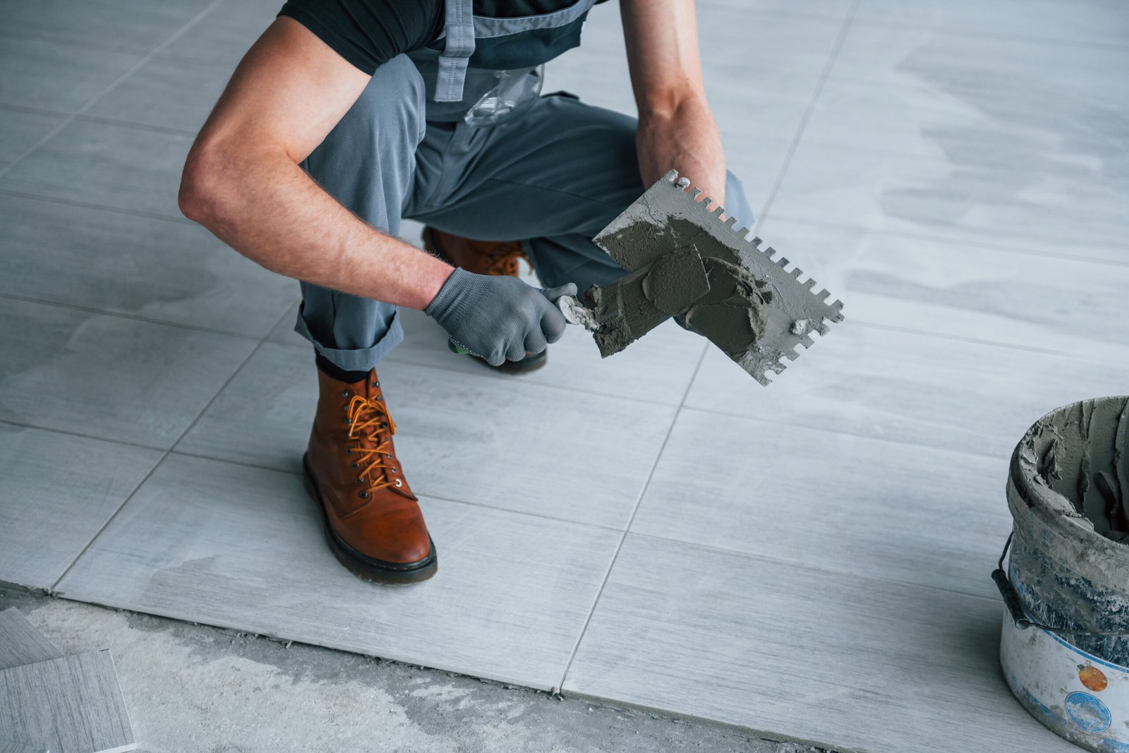 Worker applying mortar for floor tile installation